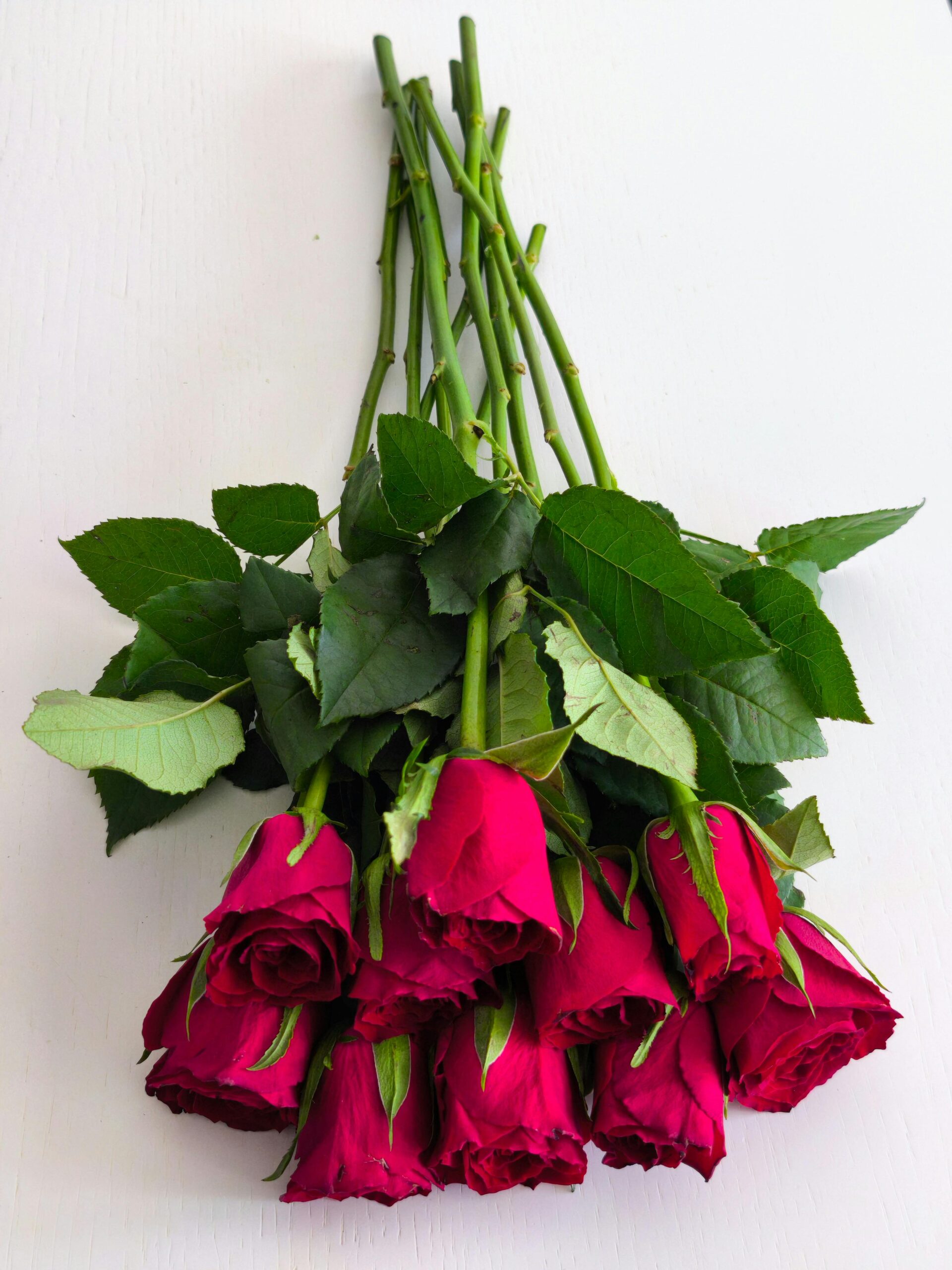 A stunning bouquet of red roses arranged on a white surface, symbolizing love and romance.